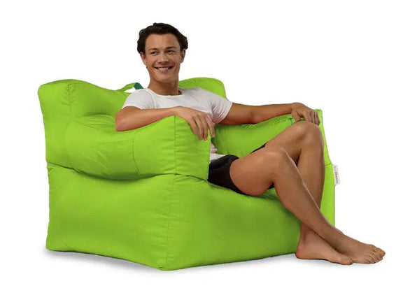 Person sitting on a large green bean bag chair against a white background