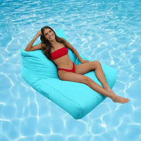 Woman in a red bikini lying on a capri blue colour bean bag in a pool.