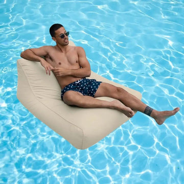 Man lounging on a beige amalfi pool float in a pool