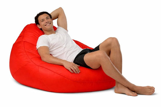 man sitting on a bright red adult bean bag chair
