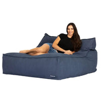 Woman sitting on a large blue bean bag chair against a white background