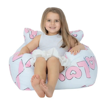 Child sitting on a bean bag with pink and black patterns on a white background