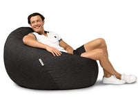 man sitting on a charcoal denim bean bag