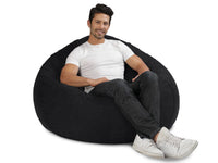 man sitting on a charcoal denim bean bag