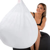 Woman peeking out from behind a white bean bag chair with a plain background