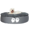 Dog lying on a gray pet bed with paw prints on a white background